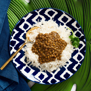 Photograph of Dal (lentil) on white Basmati Rice . It is a brown  color texture. Mouth watering! Beyond delicious.