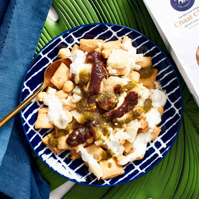 Photograph of exotic Chaat  Chips toped with Gourmet Chutneys, diced cooked potatoes, Chick Peas and Plain Yogurt. Beyond Tempting.